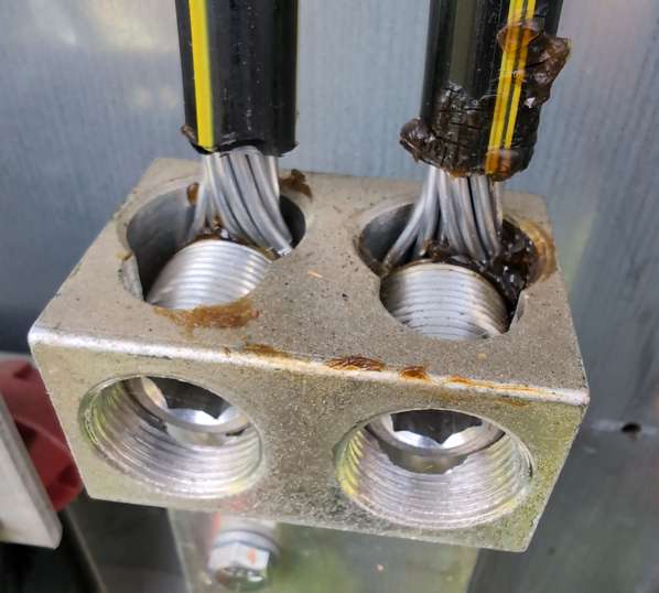 Oxide inhibitor aluminum connections — close-up of utility-side treated lug with dark DeOx compound on aluminum strands and zero oxidation